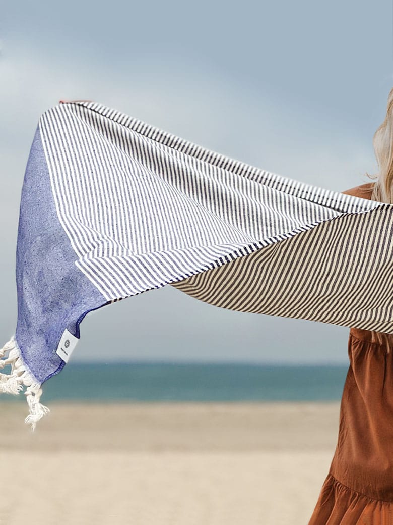 Stylish photo-shooting of the denim colour towel with white stripes and knotted fringe.