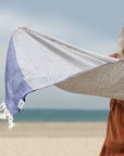 Stylish photo-shooting of the denim colour towel with white stripes and knotted fringe.