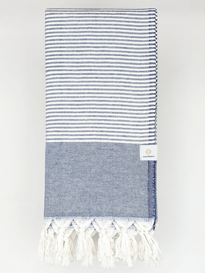 Folded a denim colour towel with white stripes and knotted fringe.