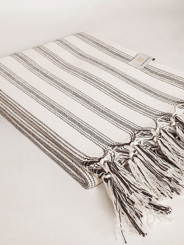 Peshtemall Striped Cotton Towel Side image of a towel with vertical black &amp; white stripes colours and knotted fringe.