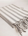 Peshtemall Striped Cotton Towel Side image of a towel with vertical black & white stripes colours and knotted fringe.