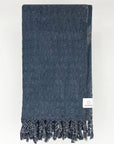 Folded towel in plain dark grey colour.