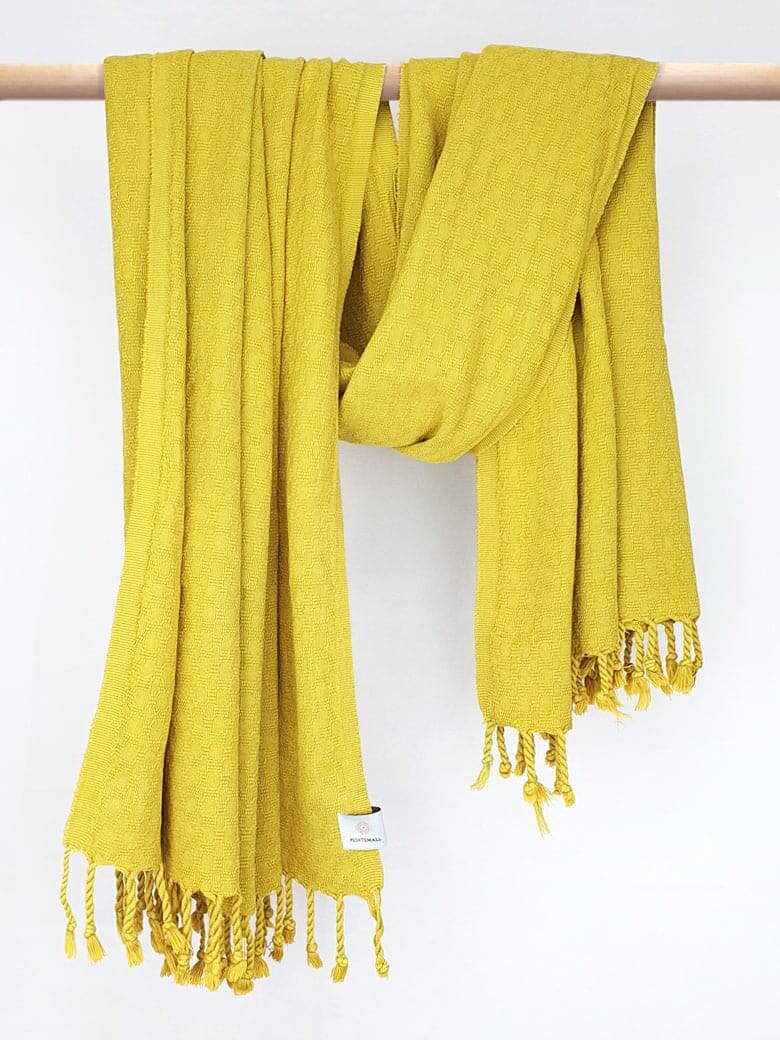 Towel in plain mustard colour with a honeycomb texture and hand-twisted style on the stick.