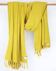 Towel in plain mustard colour with a honeycomb texture and hand-twisted style on the stick.